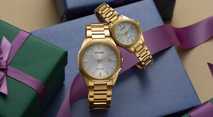 Gift Guide; Men's and women's Corso watch models BM7492-57A and EW2582-59A sitting on top of gift packages